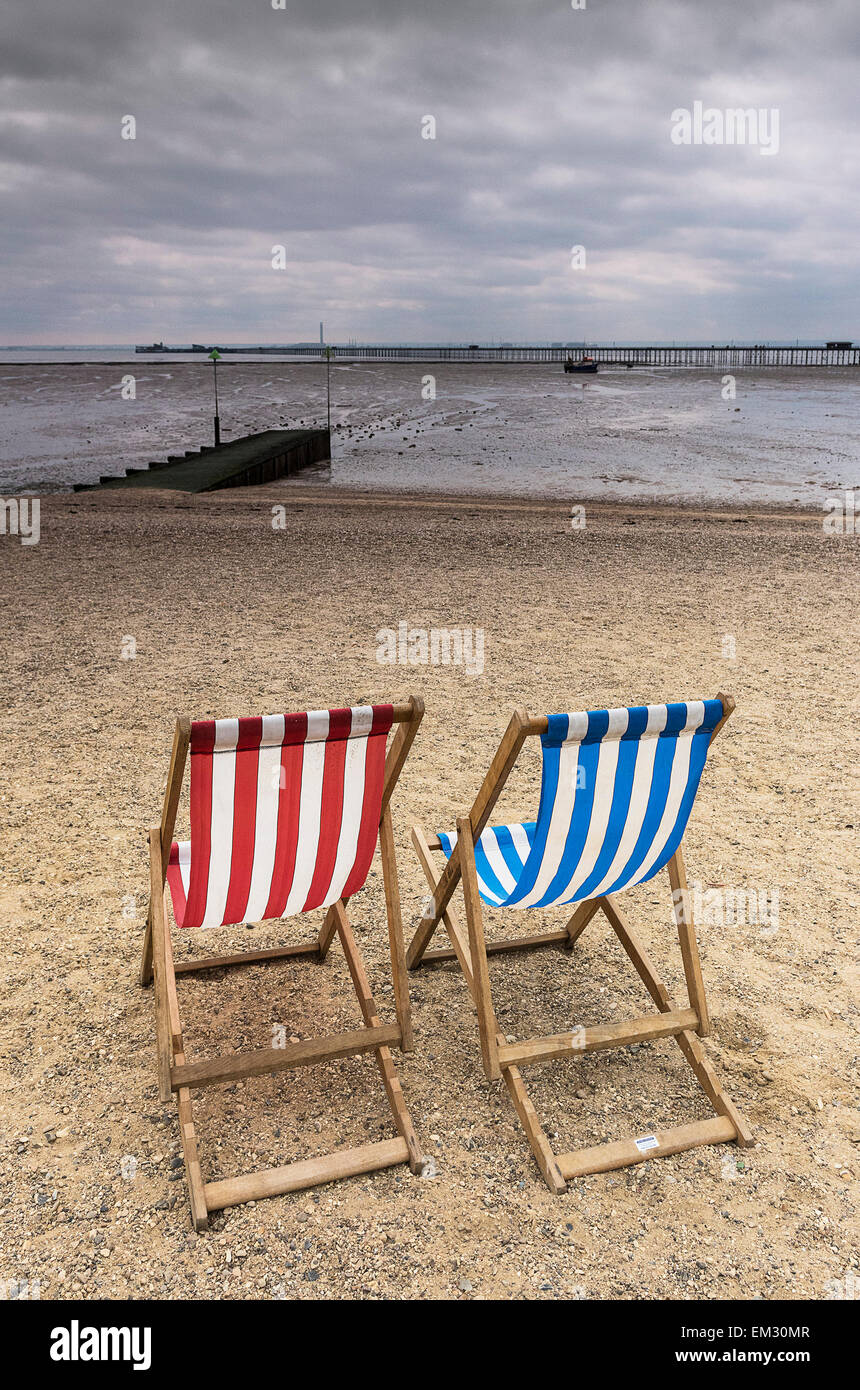 Zwei leere Liegestühle auf Jubiläum Strand in Southend an einem bewölkten Tag. Stockfoto