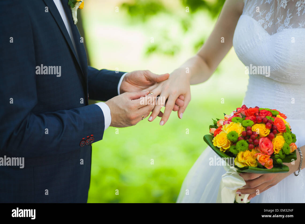 Nahaufnahme der Hände der unkenntlich Brautpaar mit Trauringe. Braut hält Hochzeit Blumenstrauß Stockfoto