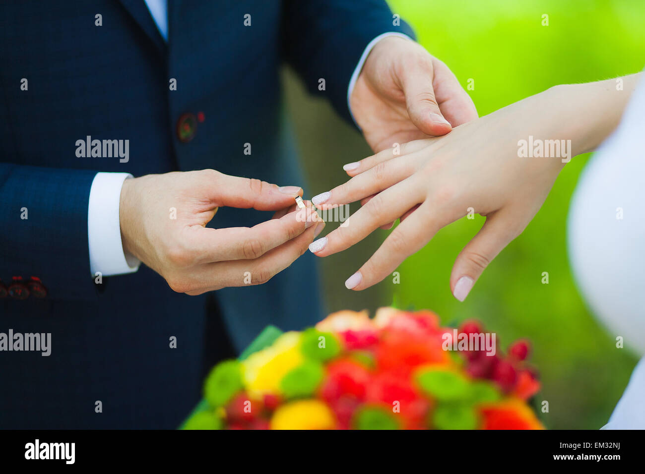 Nahaufnahme der Hände der unkenntlich Brautpaar mit Trauringe. Braut hält Hochzeit Blumenstrauß Stockfoto