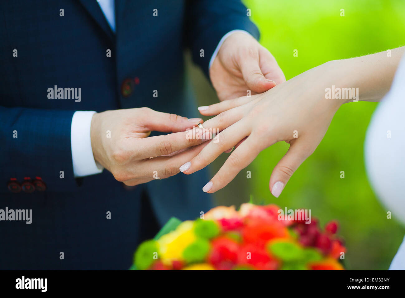 Nahaufnahme der Hände der unkenntlich Brautpaar mit Trauringe. Braut hält Hochzeit Blumenstrauß Stockfoto