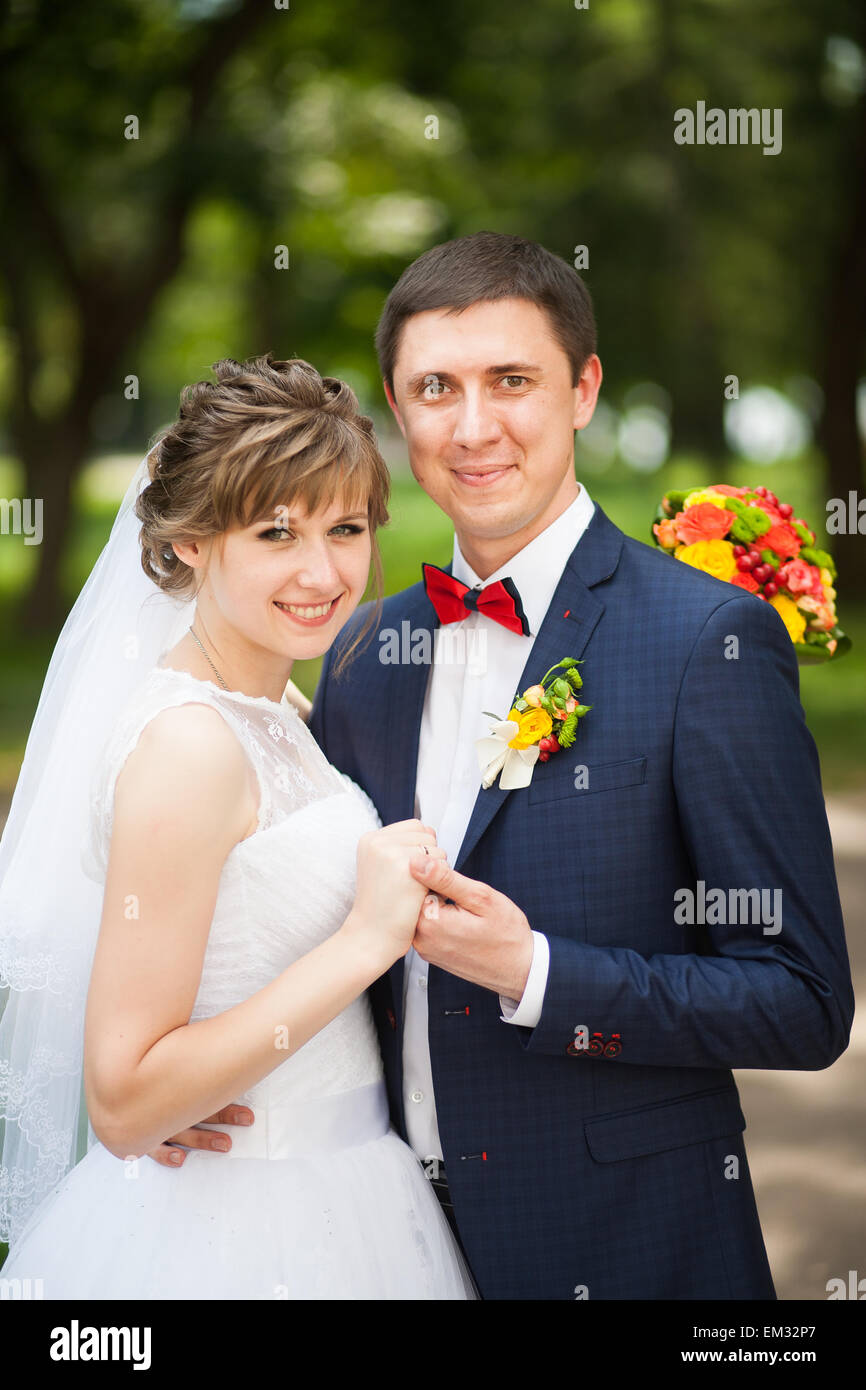 glückliche Braut, Bräutigam, stehend im grünen Park, Blick in die Kamera. Liebhaber in Hochzeitstag. glückliches junges Paar in der Liebe. Stockfoto
