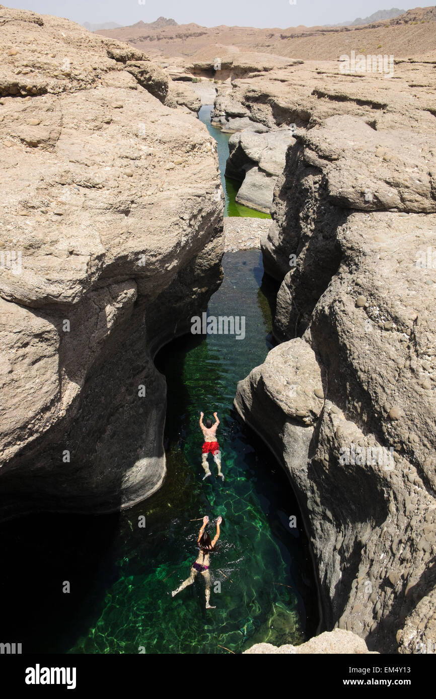 Touristen, die Schwimmen im Hatta Rock Pools natürliche Frische Wasserquellen in Oman Stockfoto