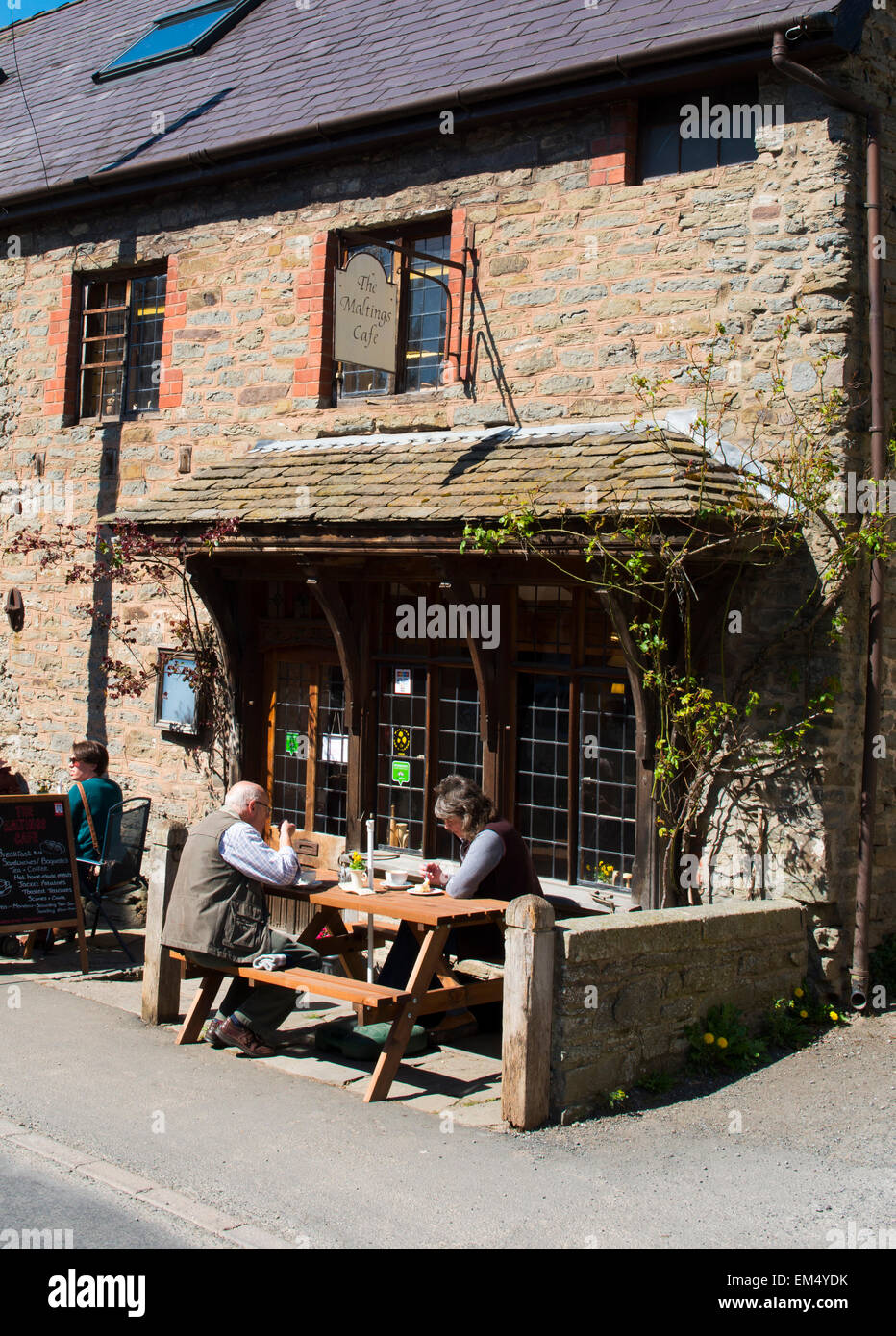 Menschen Essen und trinken außerhalb der Maltings Cafe am Clun, Shropshire, England. Stockfoto