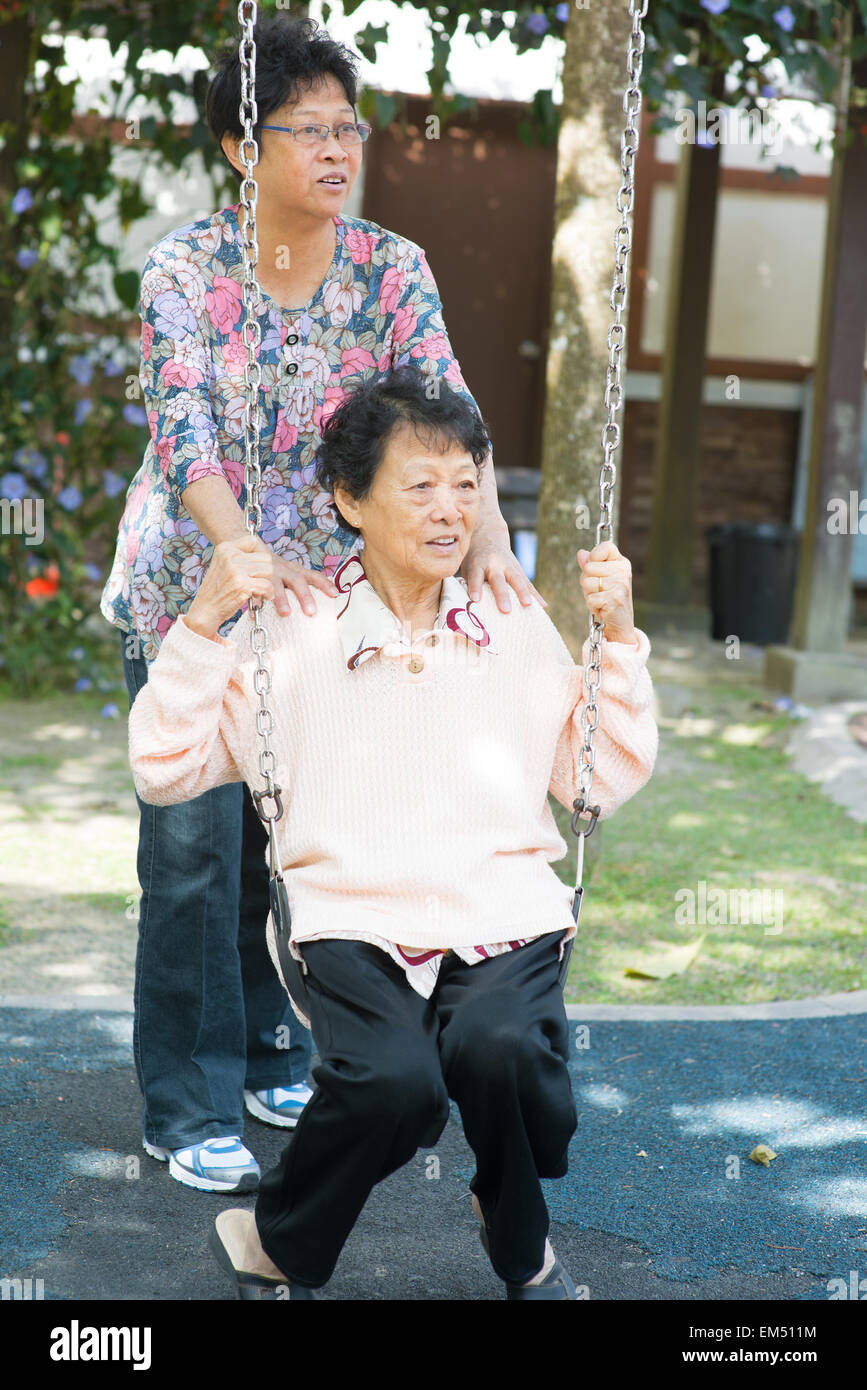 Asiatische Frauen in Führungspositionen spielen Schaukel im Garten Outdoorpark Stockfoto