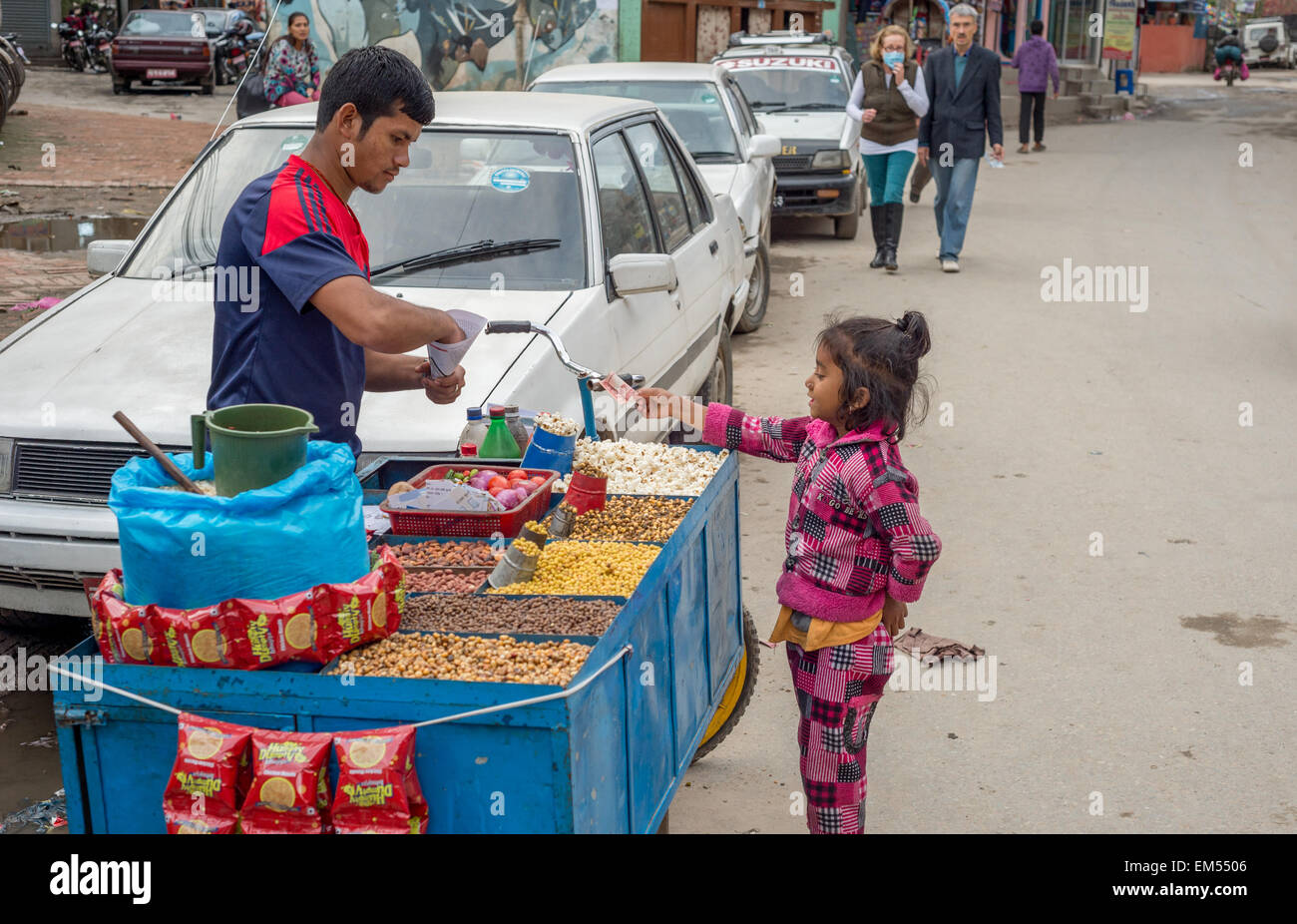Nepalesische Mädchen kaufen Pop Corn von einem Straßenhändler in Kathmandu, Nepal Stockfoto