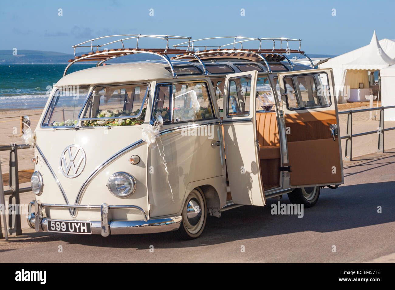 VW Wohnmobil geparkt auf der Promenade am Strand von Bournemouth für eine Hochzeit am Strand mit Hochzeit Marque Festzelt hinter Stockfoto