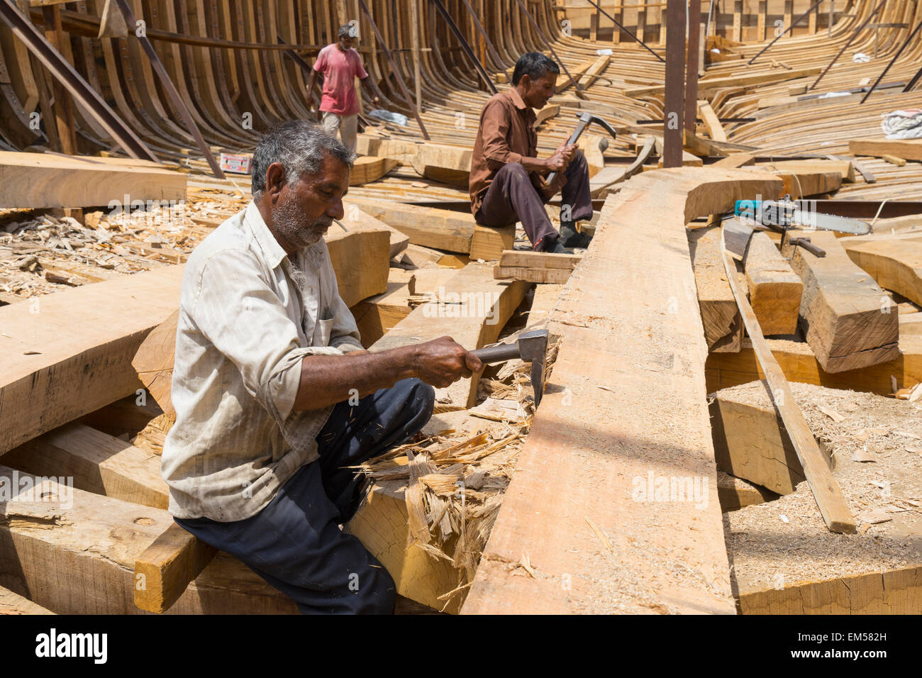 Handwerker Bau einer traditionellen hölzernen Dhau-Ladung Schiff in der Werft neben The Creek River in Dubai Vereinigte Arabische Emirate Stockfoto