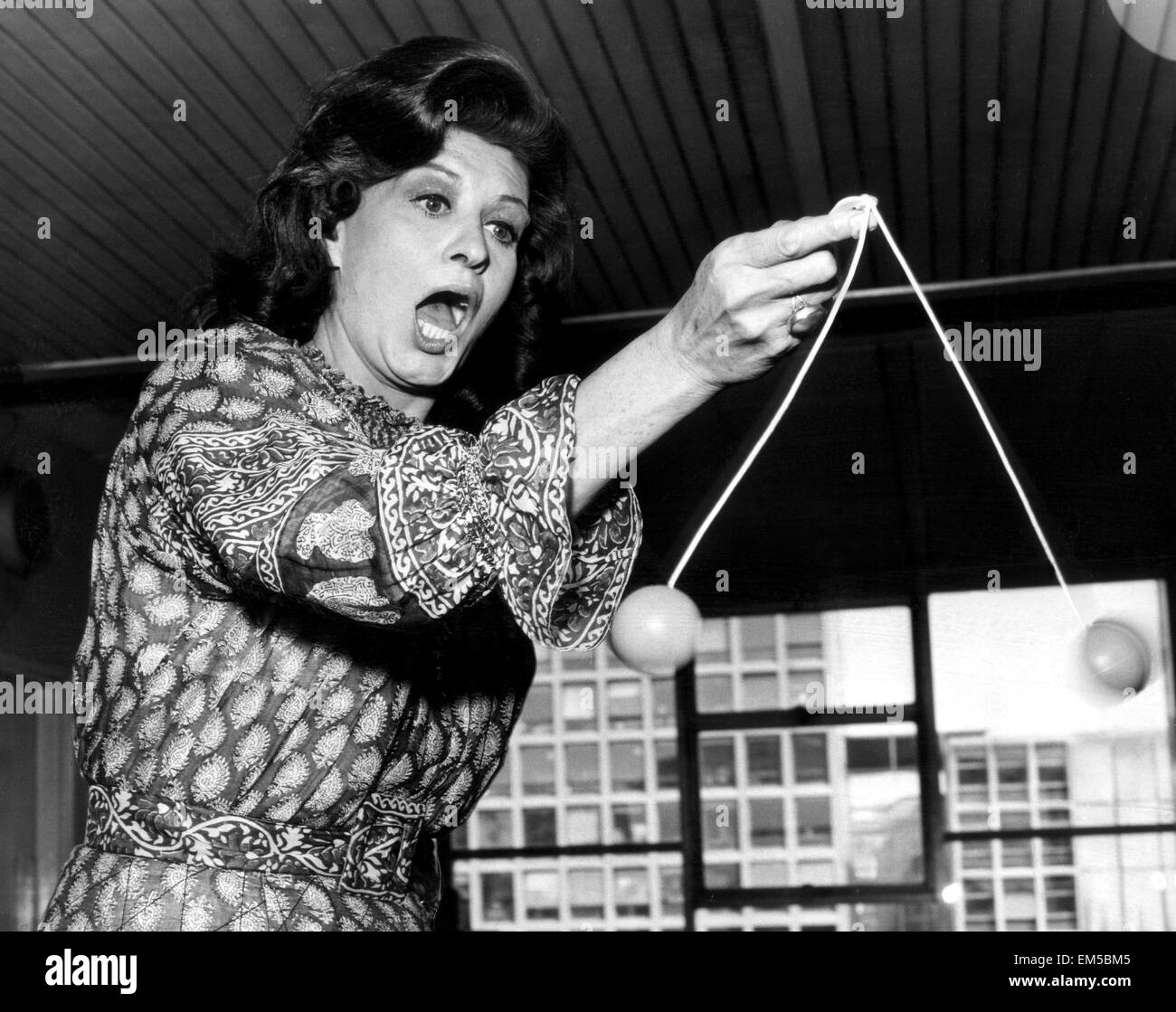 Model Caroline Munroe versucht in den Griff bekommen mit der letzte Schrei, Ker-Türklopfer. 20. August 1971. Stockfoto