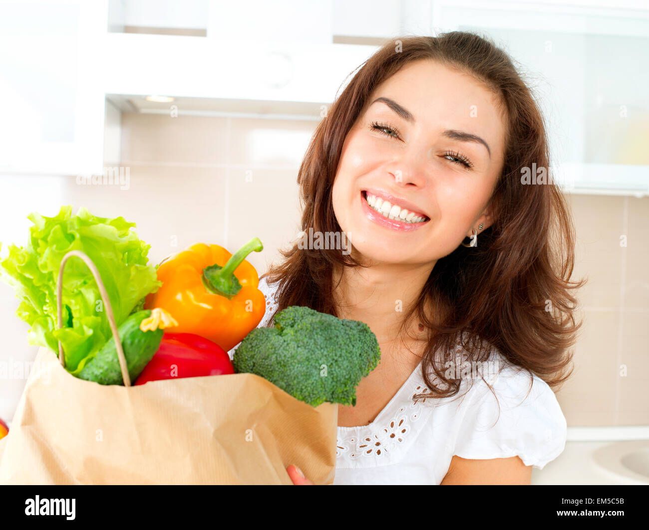 Glückliche junge Frau mit Gemüse im Warenkorb. Diät-Konzept Stockfoto