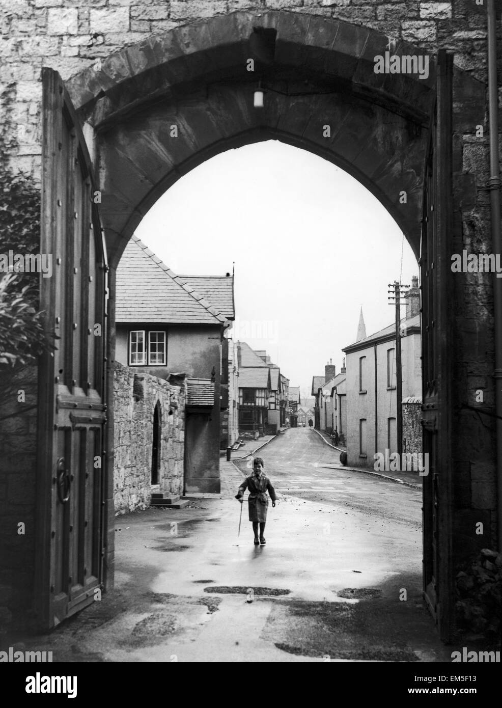 Ein kleiner Junge geht durch den Torbogen am Eingang des Ruthin Castle Denbighshire Februar 1944 Stockfoto