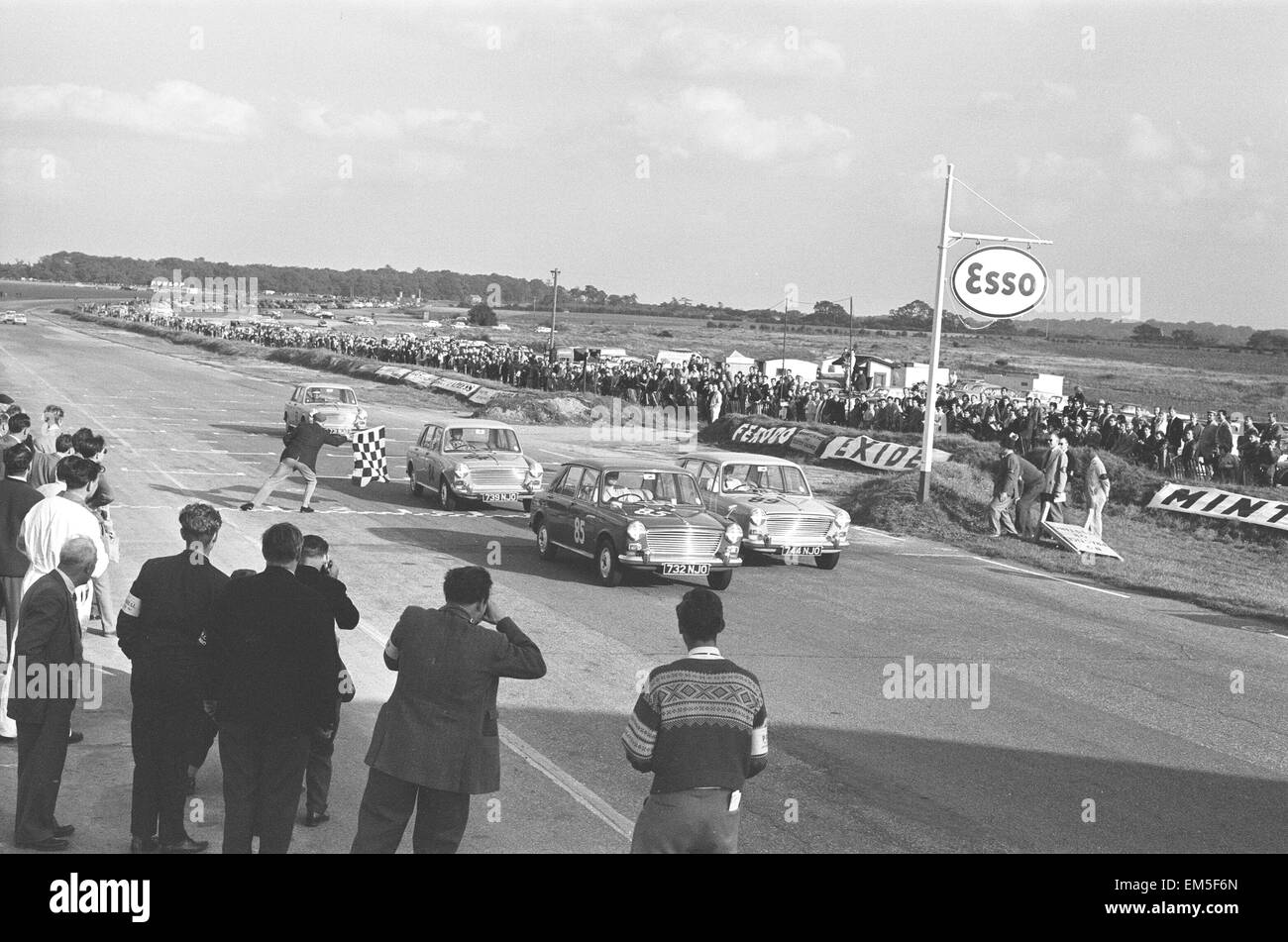 Konkurrenten nehmen die Zielflagge beim Molyslip Morris 1100 Rennen in Snetterton Rennstrecke in Norfolk. 29. September 1963 Stockfoto