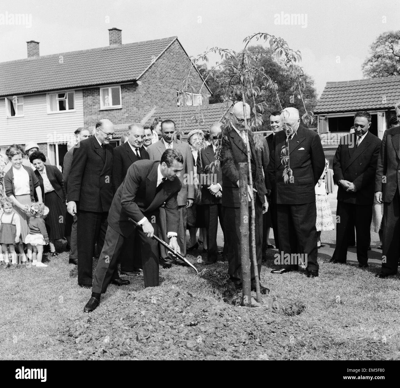 Mohammad-Reza Schah Pahlavi, Schah von Persien pflanzt einen Baum, die von den Bewohnern der Makepieace Straße in der Neustadt von Bracknell während seines Besuchs in Großbritannien beobachtet. 7. Mai 1959. Stockfoto