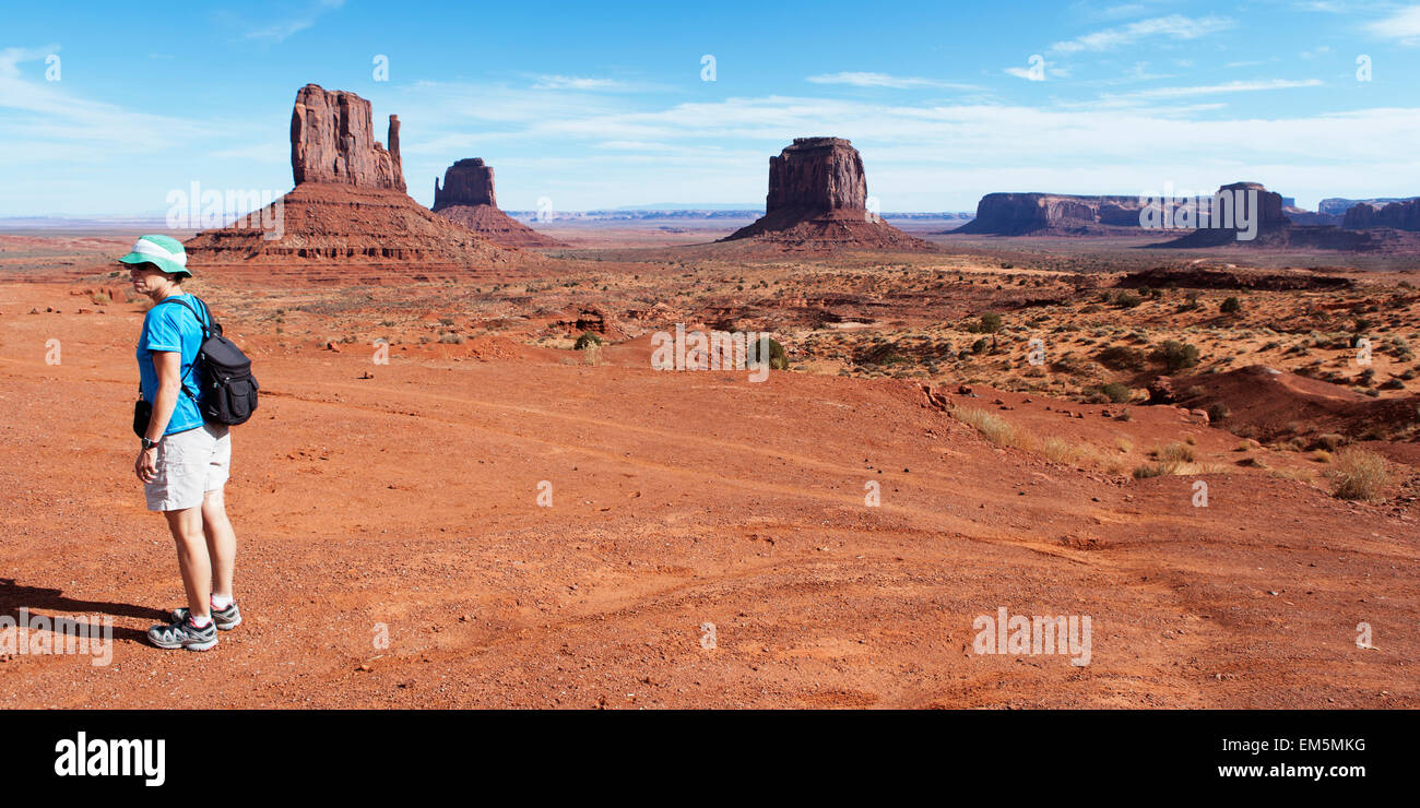 Eine weibliche Wanderer steht allein im Monument Valley und Sandstein Buttes. Stockfoto