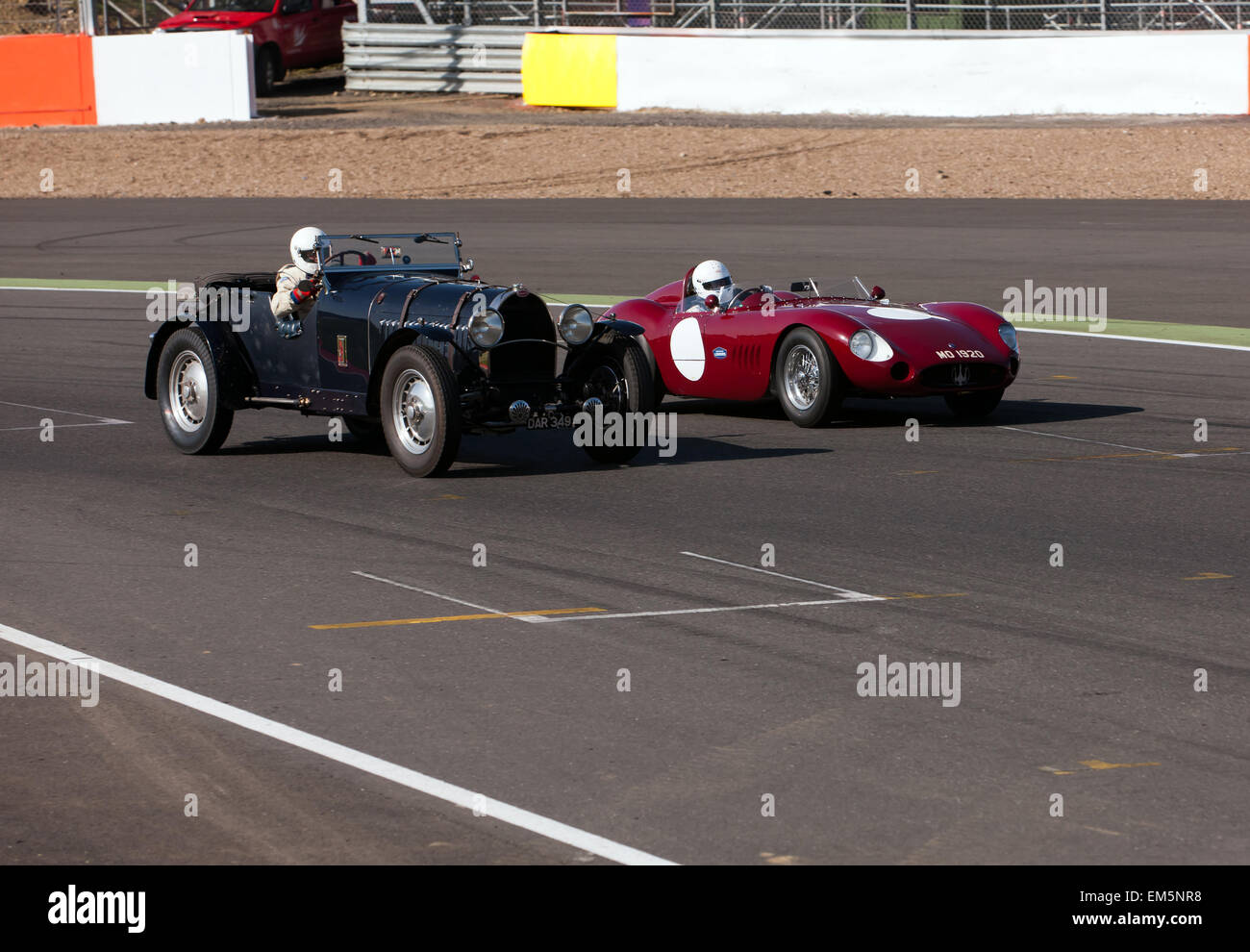 Fahrer immer verfolgen Sie Zeit mit ihrer klassischen Rennwagen. Ein Bugatti und ein Maserati nebeneinander beim Eintritt in der finishing-Straße an der berühmten Rennstrecke von Silverstone. Stockfoto