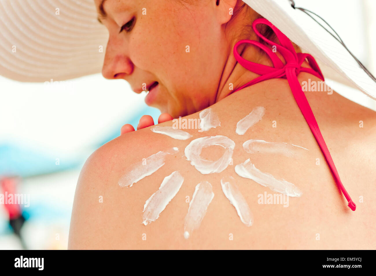 Sonne Sonnencreme auf seiner Schulter eine schöne junge Frau gezeichnet Stockfoto