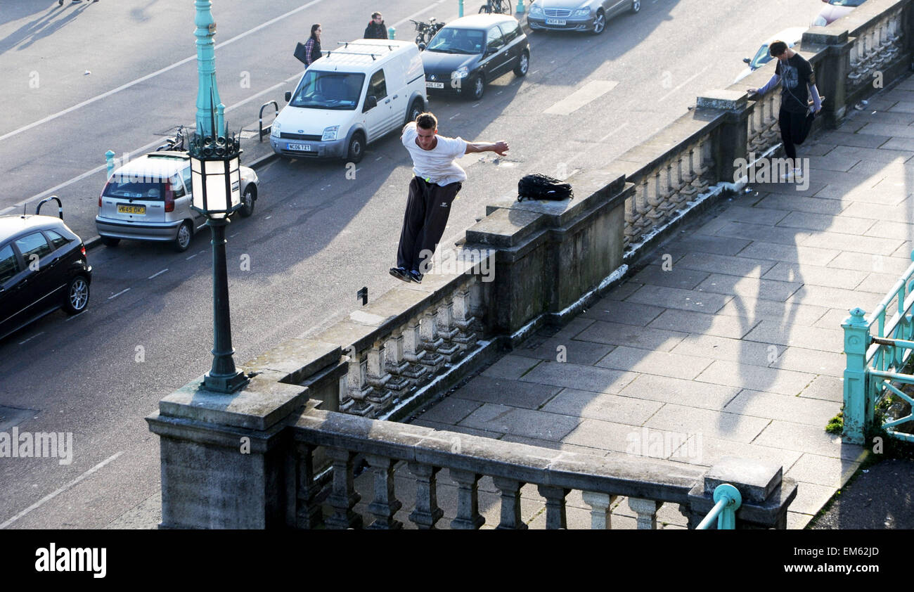 Brighton UK Praktiken 15. April 2015 - ein junger Mann seine Parkour springen oder freilaufend über Madeira Drive in Brighton Seafront am frühen Abend Stockfoto