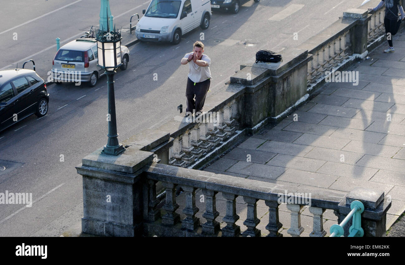 Brighton UK Praktiken 15. April 2015 - ein junger Mann seine Parkour springen oder freilaufend über Madeira Drive in Brighton Seafront am frühen Abend Foto von Simon Dack Stockfoto