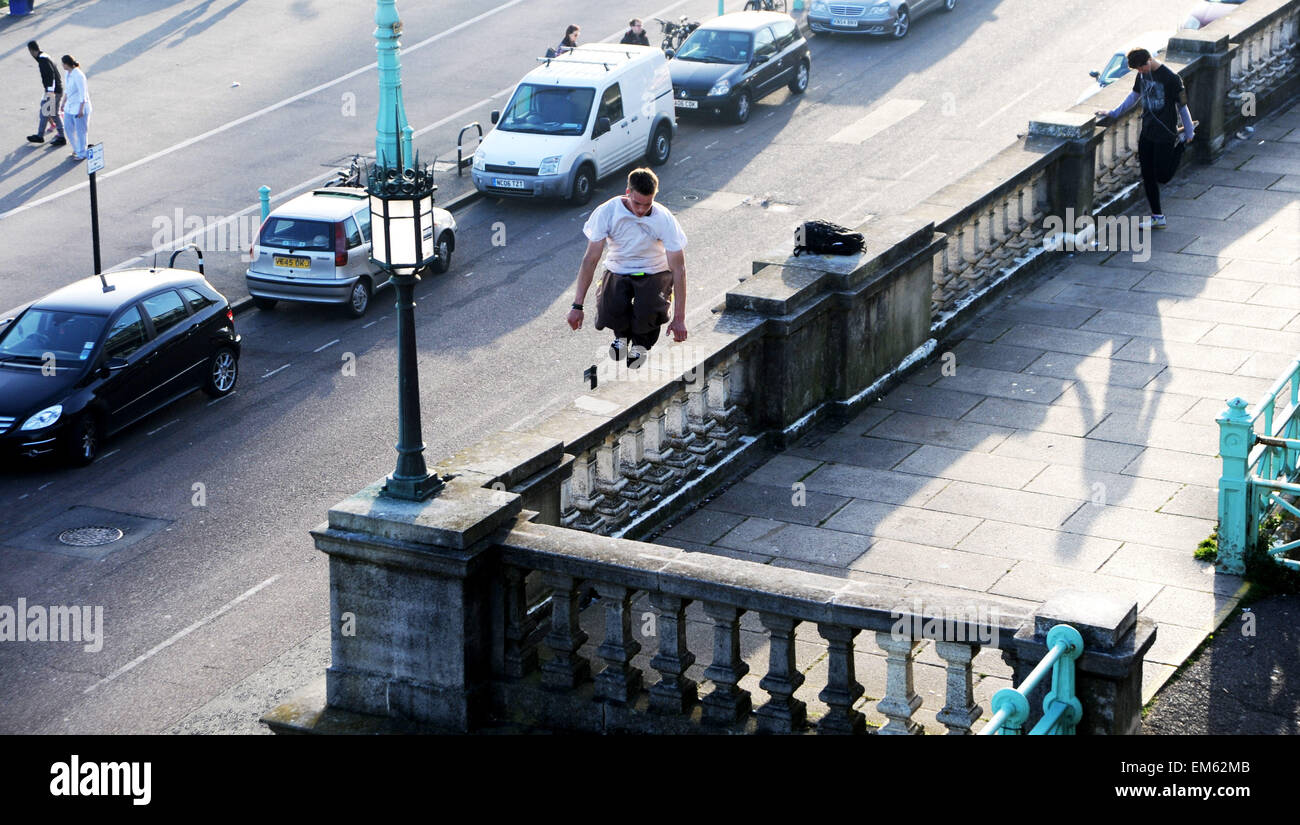 Brighton UK Praktiken 15. April 2015 - ein junger Mann seine Parkour springen oder freilaufend über Madeira Drive in Brighton Seafront am frühen Abend Foto von Simon Dack Stockfoto