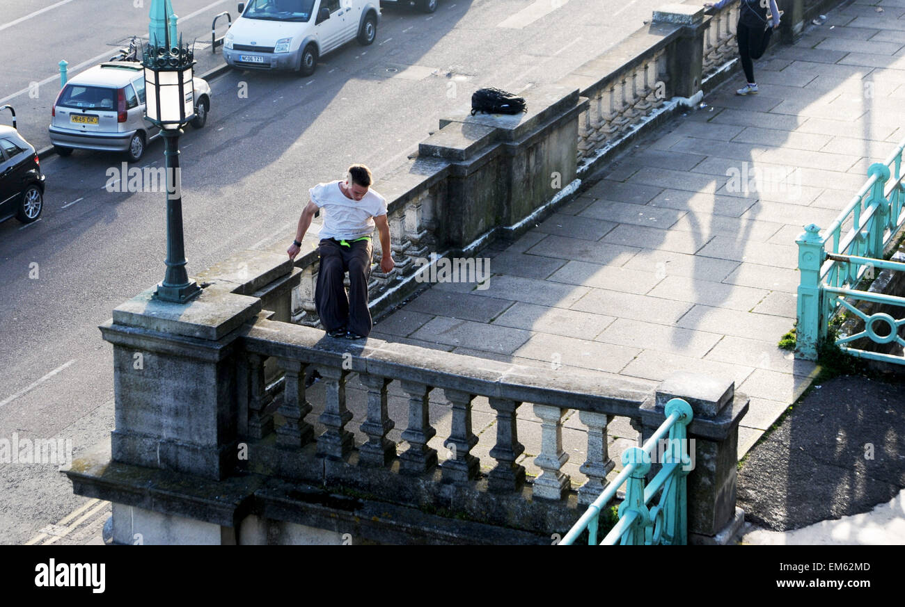 Brighton UK Praktiken 15. April 2015 - ein junger Mann seine Parkour springen oder freilaufend über Madeira Drive in Brighton Seafront am frühen Abend Stockfoto