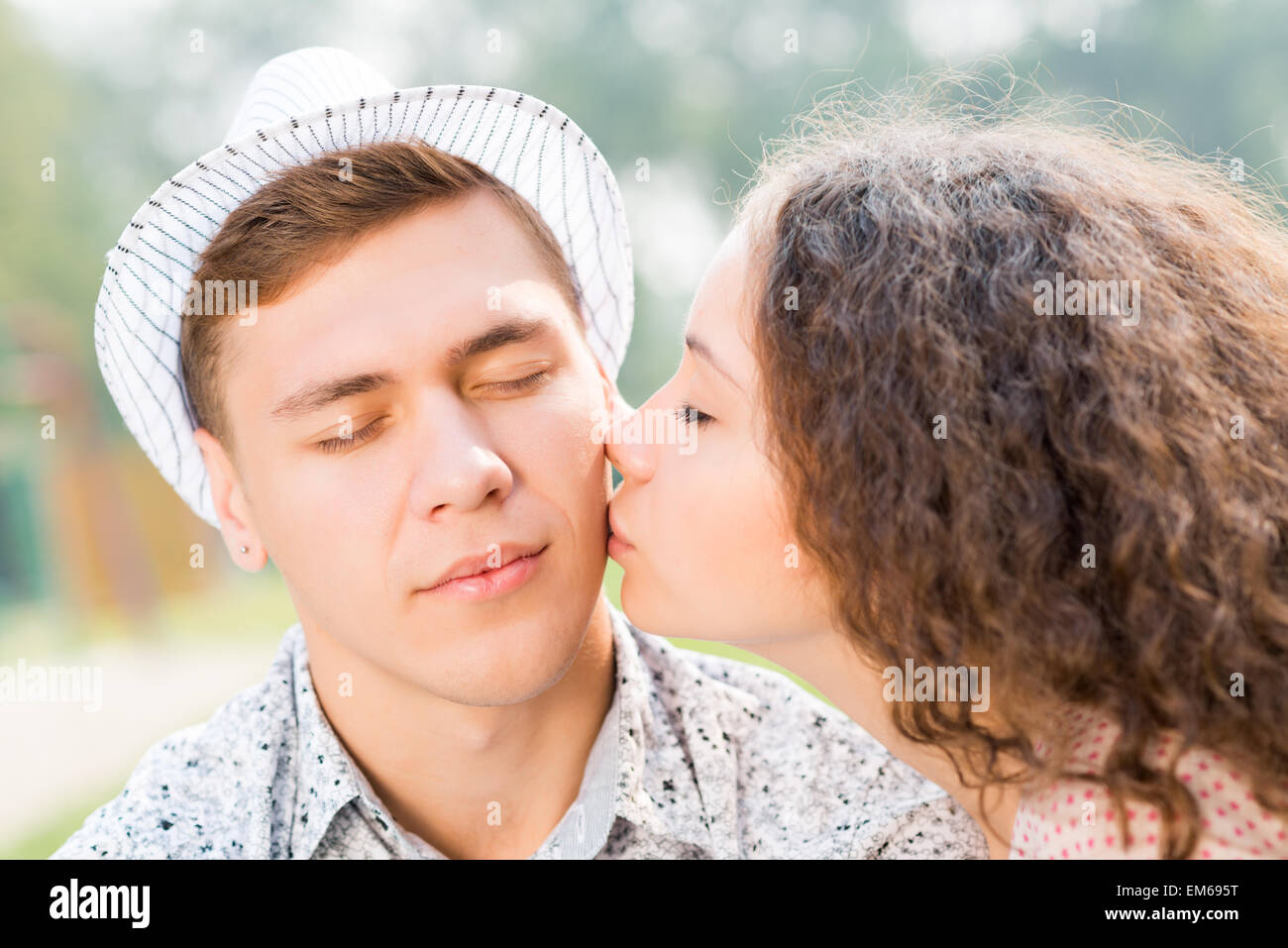 Mädchen, die einen Mann auf die Wange küssen Stockfoto