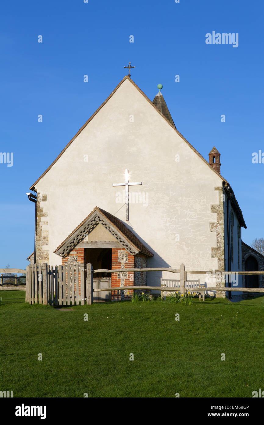 St.-Hubertus Kirche. Nahaufnahme der Kirche auf dem Hügel mit der Einstellung Sunburst oben auf das Kreuz. Frühling Narzissen. Stockfoto