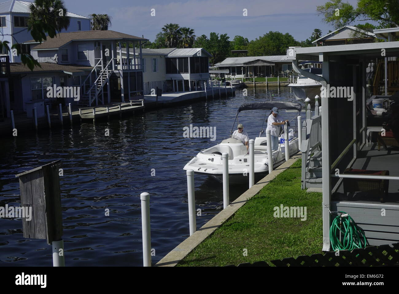 Frau bindet ein Boot an einem Kanal vor der Homosassa River, Florida Stockfoto