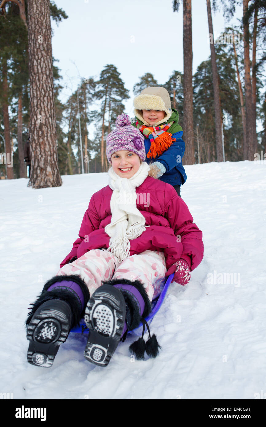Kinder auf dem Schlitten im Schnee Stockfoto