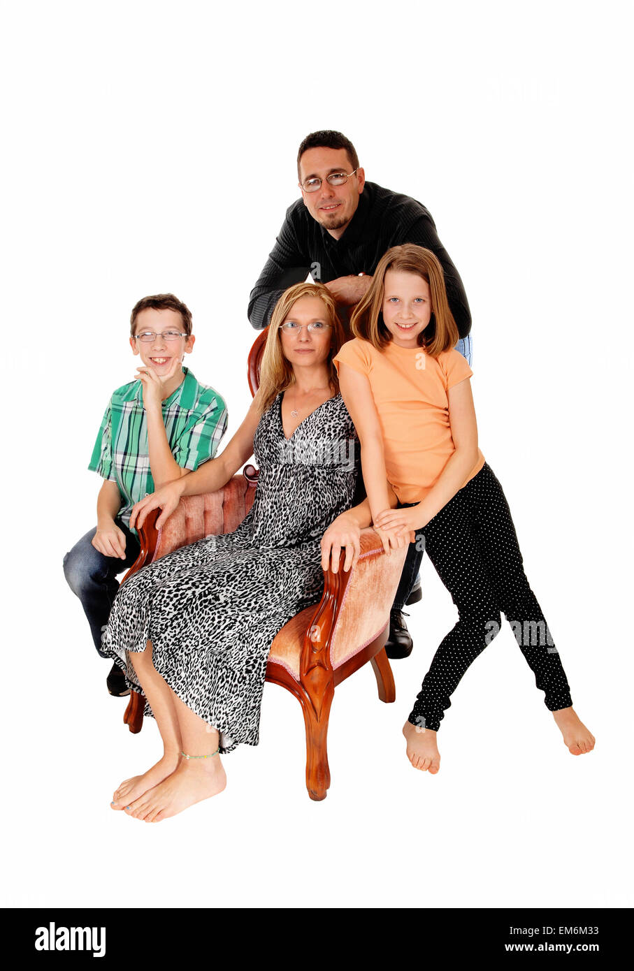 Eine Familiengruppe, die Mutter in einem rosa Sessel und der Ehemann, Tochter und Sohn stehend, sitzend für weißen Hintergrund isolieren. Stockfoto