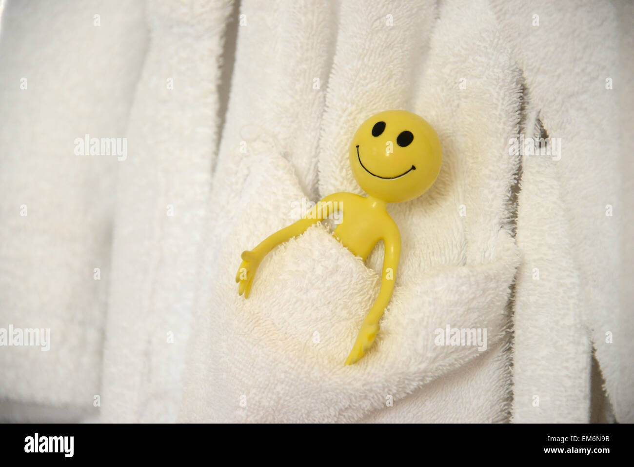 Gelber Smiley-Mann im Urlaub in die äußeren Hebriden-hier ist er bequem in der Hosentasche einen Morgenmantel aus dem Spa entspannend Stockfoto