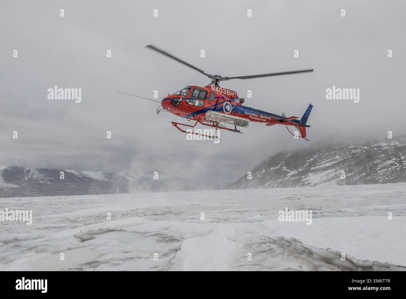 Ein Hubschrauber landet bei schlechtem Wetter auf dem Commonwealth-Gletscher der Antarktis. Stockfoto