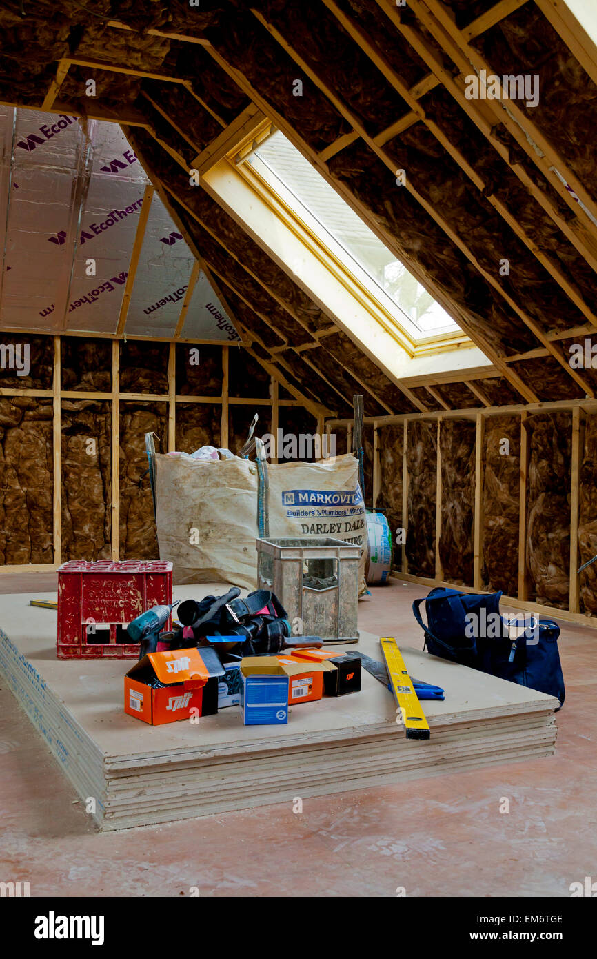 Baustoffe in eine Dachfläche auf einer Baustelle zeigt Isolierung Wolle zwischen Holzbalken vor Abschluss der Wand platziert Stockfoto