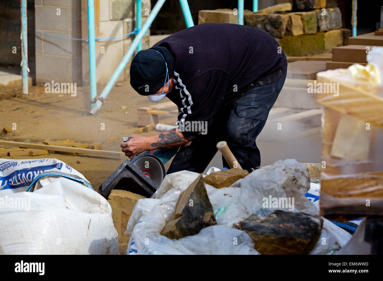 Bauarbeiter auf der Baustelle mit Kreissäge, Stein in Form geschnitten Stockfoto