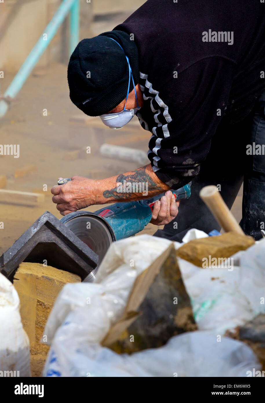 Generator arbeitet an einem Bau Website Schneiden von Stein mit einer Kreissäge Stockfoto