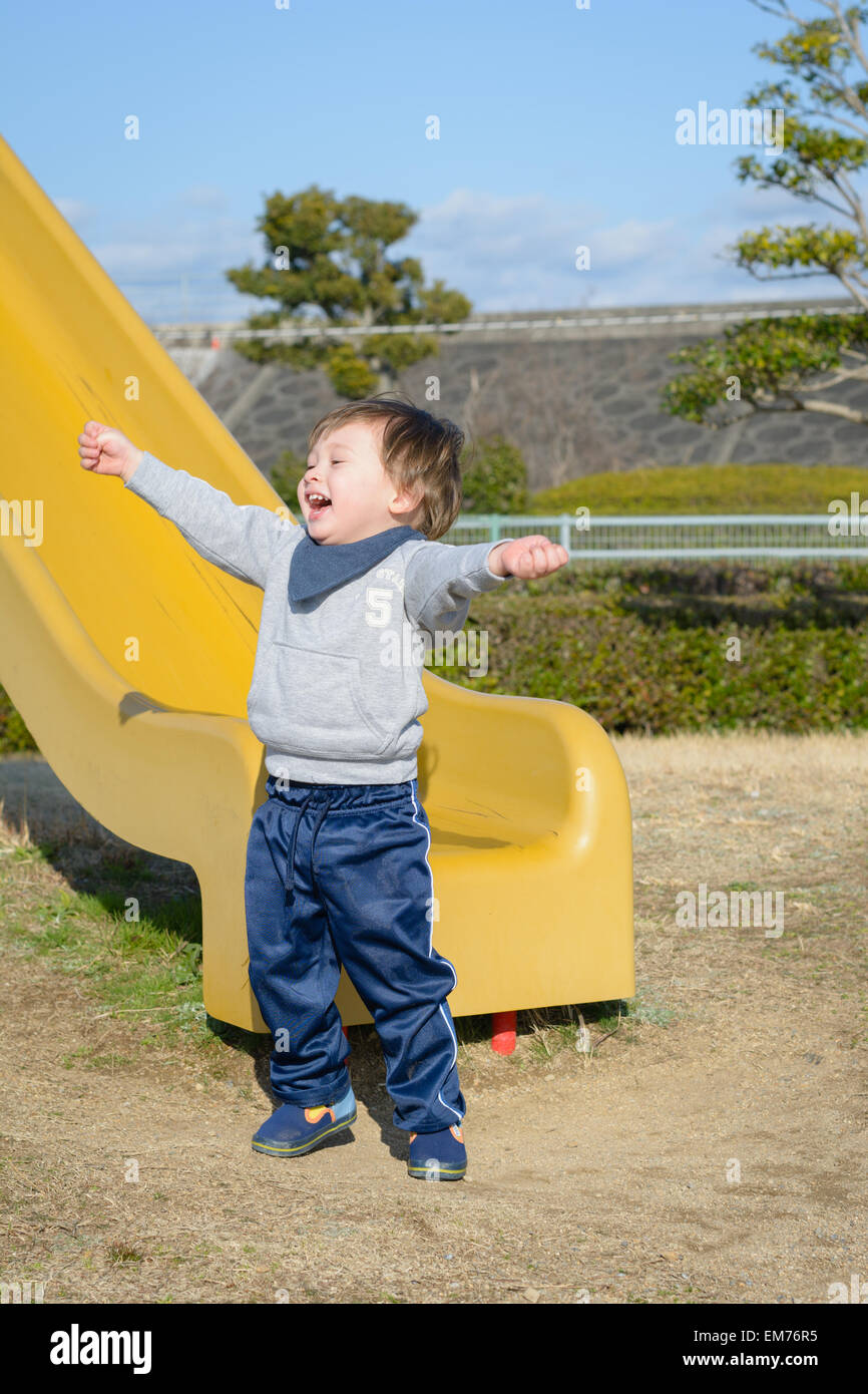 Ein 2 jähriger Junge nach einer Rutsche hinunter zu feiern. Stockfoto