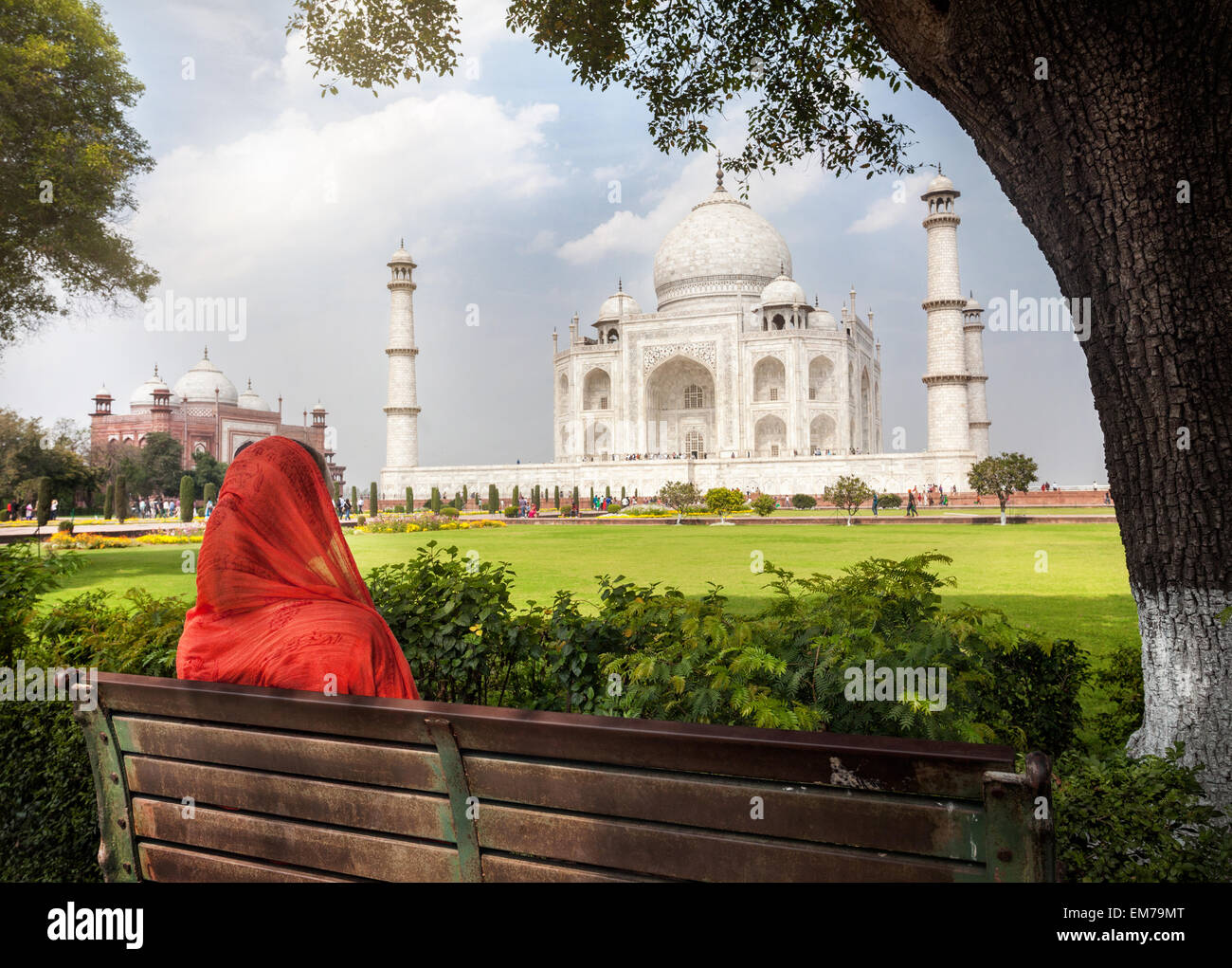 Frau im roten Schal auf der Bank im Schatten sitzen und mit Blick auf das Taj Mahal in Agra, Uttar Pradesh, Indien Stockfoto