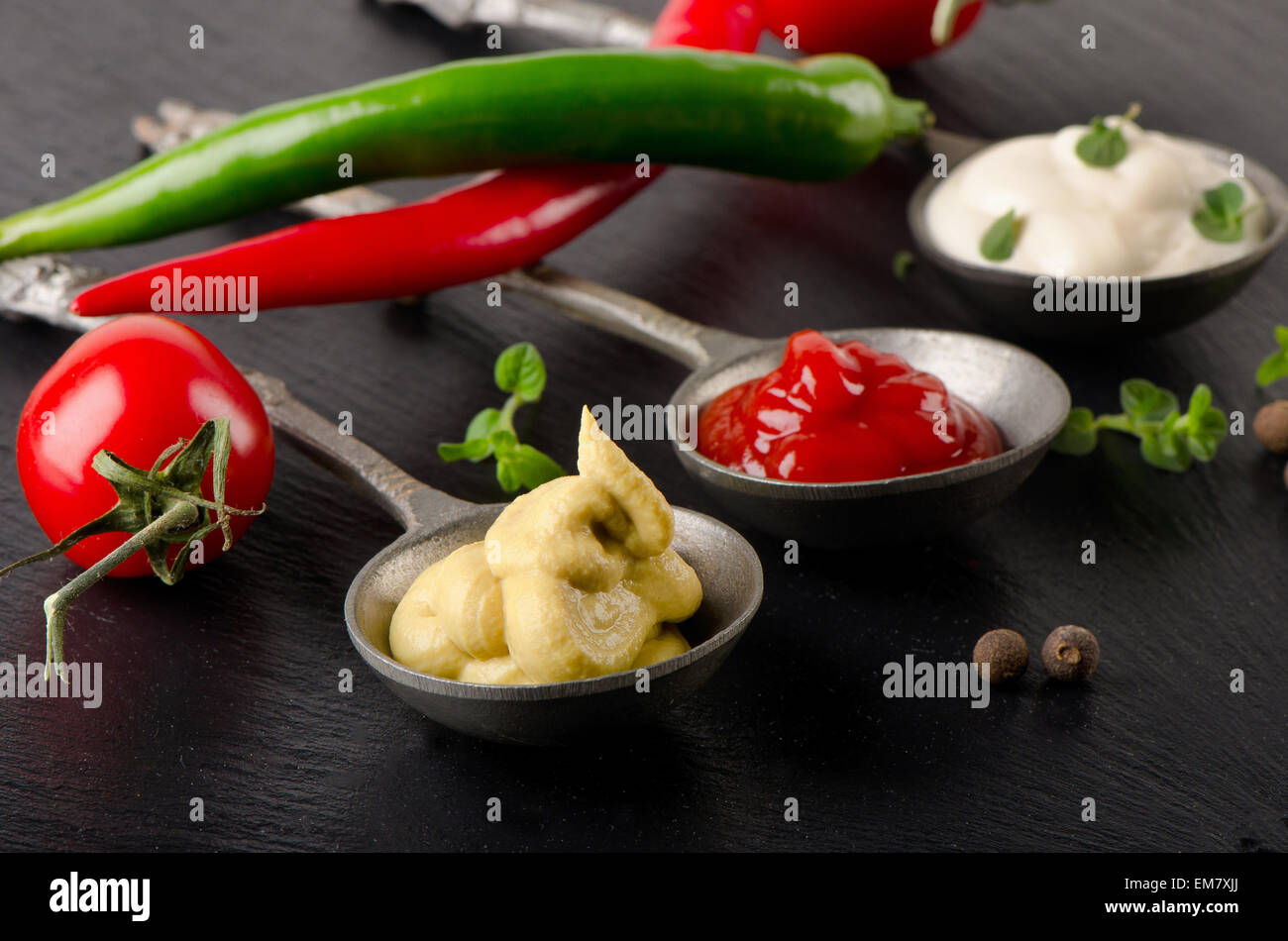 Tomatensauce, Senf und Mayonnaise auf einem schwarzen Tisch. Selektiven Fokus Stockfoto