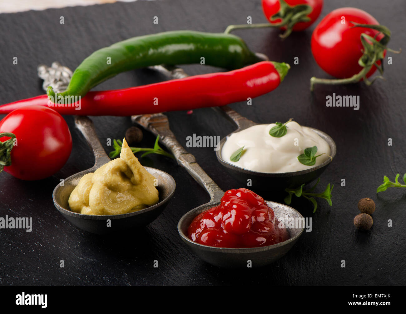 Senf, Ketchup und Mayonnaise auf einem schwarzen Tisch. Selektiven Fokus Stockfoto
