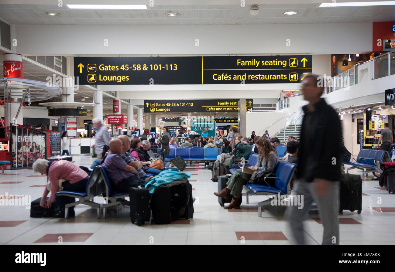 Menschen warten in der Abflughalle am Flughafen Gatwick, England Stockfoto