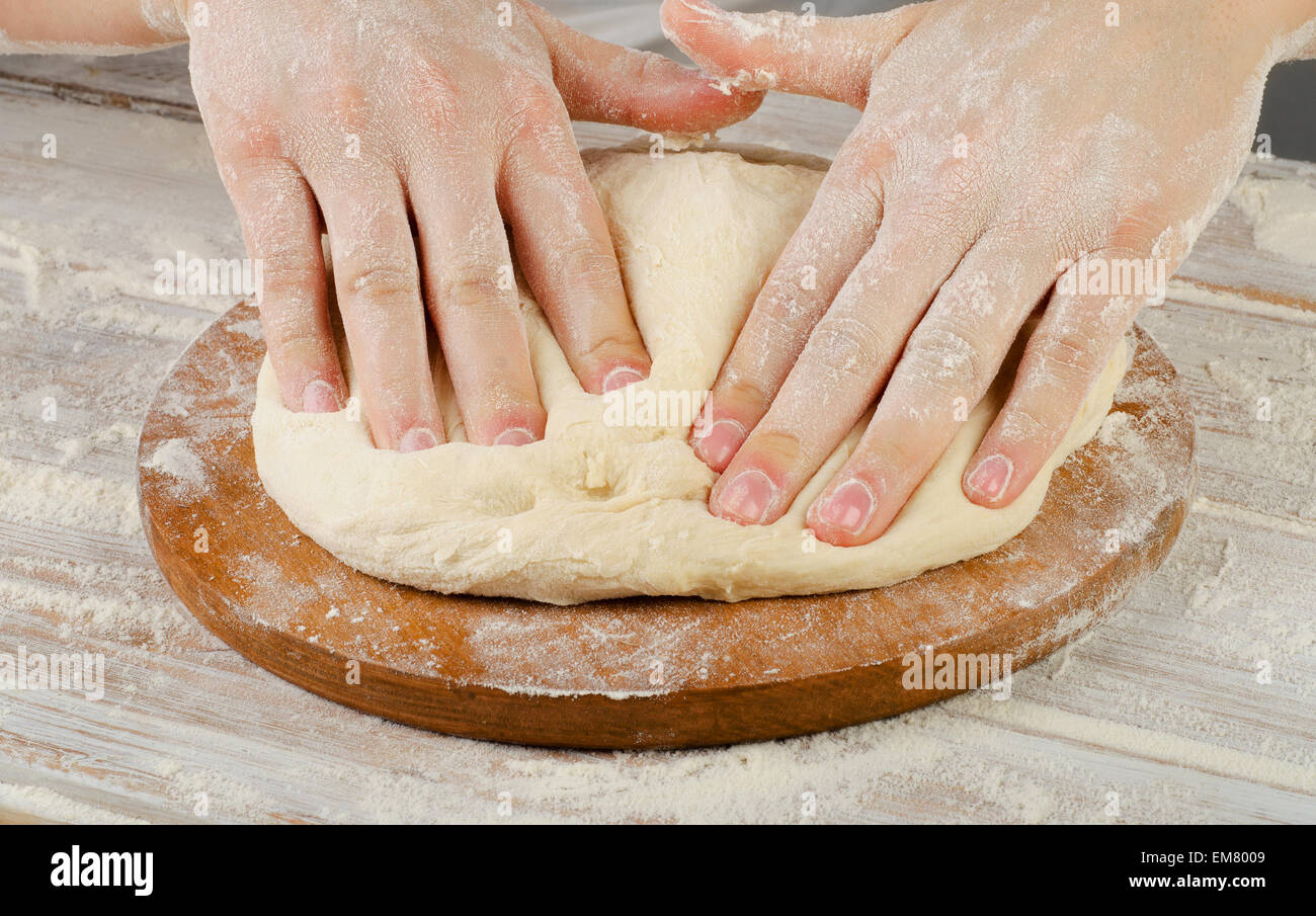 Frau auf einem Holzbrett Teig vorbereiten. Selektiven Fokus Stockfoto