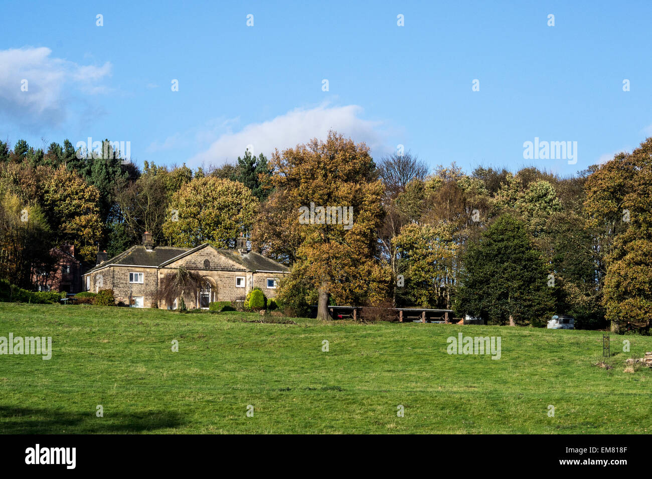 Landschaft ein Häuschen auf dem Land neben Bäumen und ein Feld Stockfoto