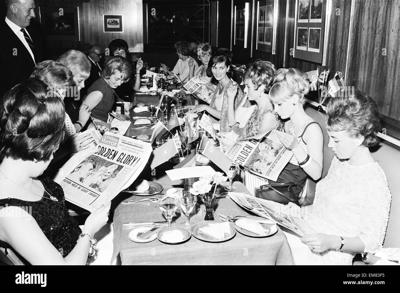 1966-World-Cup-Turnier in England. Ein Welt-Cup-Bankett fand für das Siegerteam England im Royal Garden Hotel nach ihrem Sieg über Westdeutschland im Finale im Wembley-Stadion statt. Ehefrauen von den Spielern, die getrennt von ihren Ehemännern, einschließlich Frau Tina Moore, Frau Peters, Frau Hurst, Frau Springett und Frau Bonetti Lesen der Zeitung Sunday Mirror Essen musste. 31. Juli 1966. Stockfoto