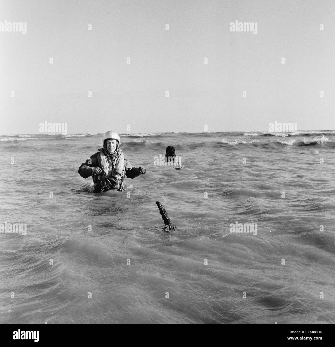 Master-Navigator Colin Walsh von der RAF Air Sea Rescue Service steht hüfthoch im Wasser auf einer Sandbank bei Goodwin Sands, direkt an der Küste von Ramsgate, nach der Entdeckung der ein RAF Lancaster-Bomber, die nicht zu Hause von seiner Mission im zweiten Weltkrieg. Die Männer von der RAF Rettungsdienst bei Manston in Kent die Meere kontinuierlich scannen und entdeckt die drei Propeller ragte aus dem Wasser, führen sie einen genaueren Blick werfen. 6. Februar 1964. Stockfoto