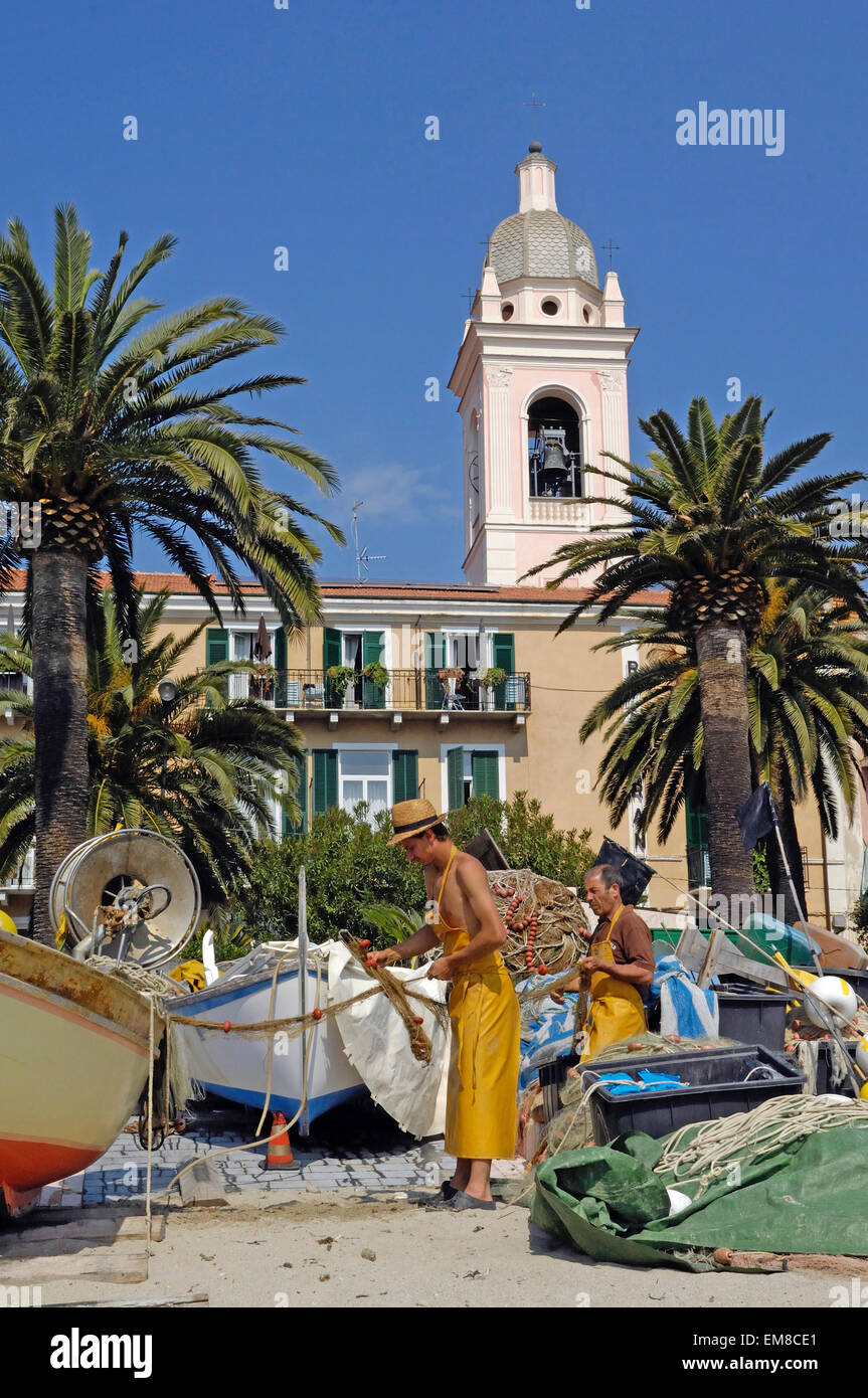Fischer mit einem Fischerboot am Strand von Noli, Riviera di Ponente, Ligurien, Italien Stockfoto