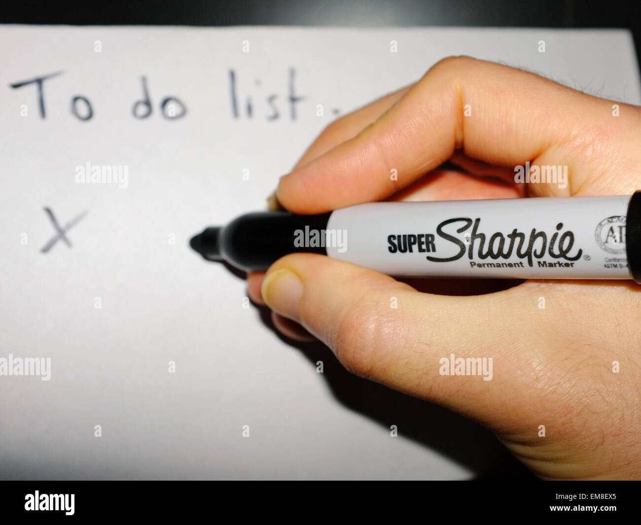 Eine weiße Hand einen Sharpie Stift eine "To do-Liste" auf ein Blatt Papier schreiben. Stockfoto