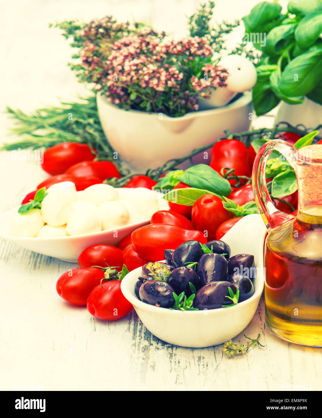 Frischem Basilikum, Tomaten, Mozzarella und Olivenöl. Essen-Hintergrund. Caprese Salatzutaten. Retro-Stil getönten Bild Stockfoto