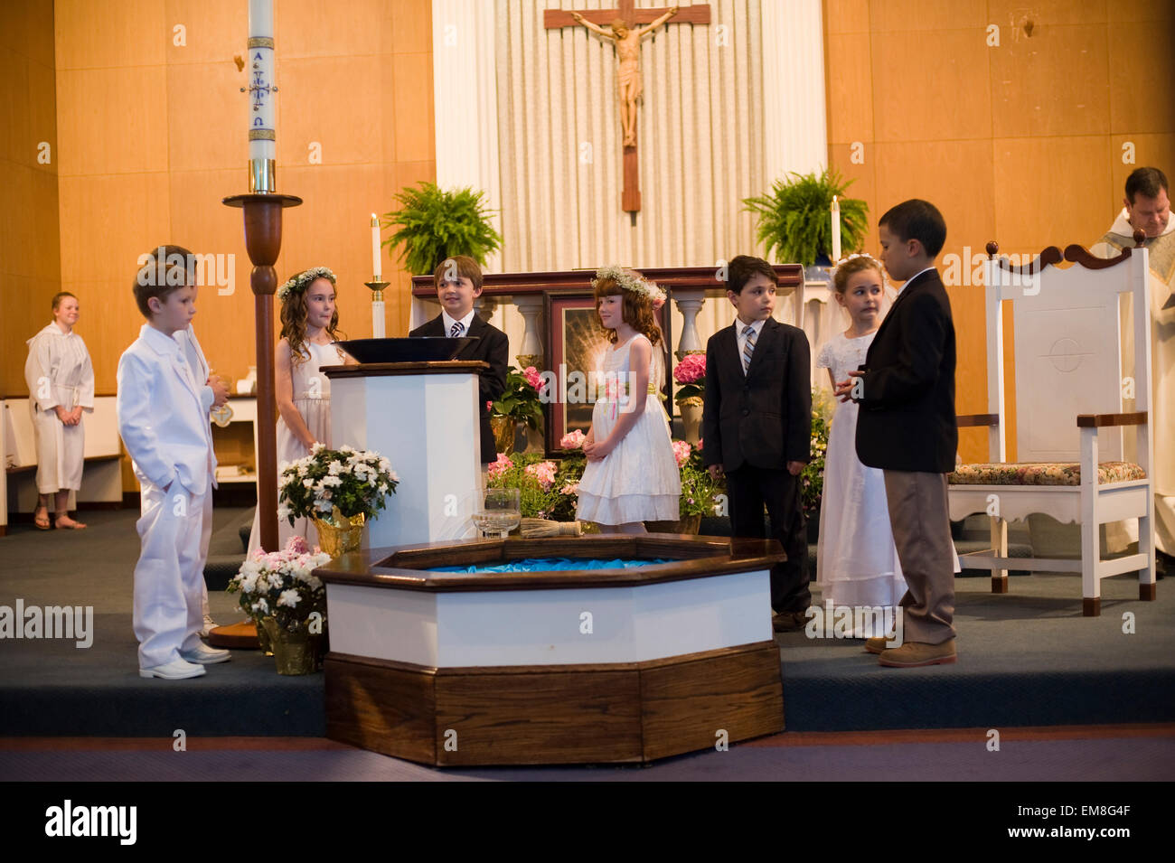 Sieben Jahre alten Jungen und Mädchen warten auf dem Altar einer katholischen Kirche während ihrer ersten Heiligen Kommunion Zeremonie (nicht Modell freigegeben) Stockfoto