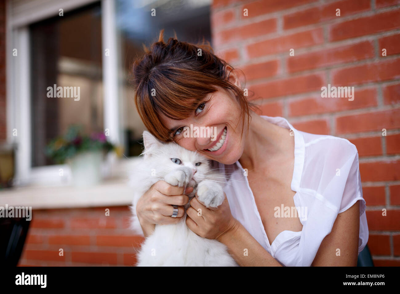 Porträt von Mitte Erwachsene Frau und nur ungern Katze vor Haustür Stockfoto