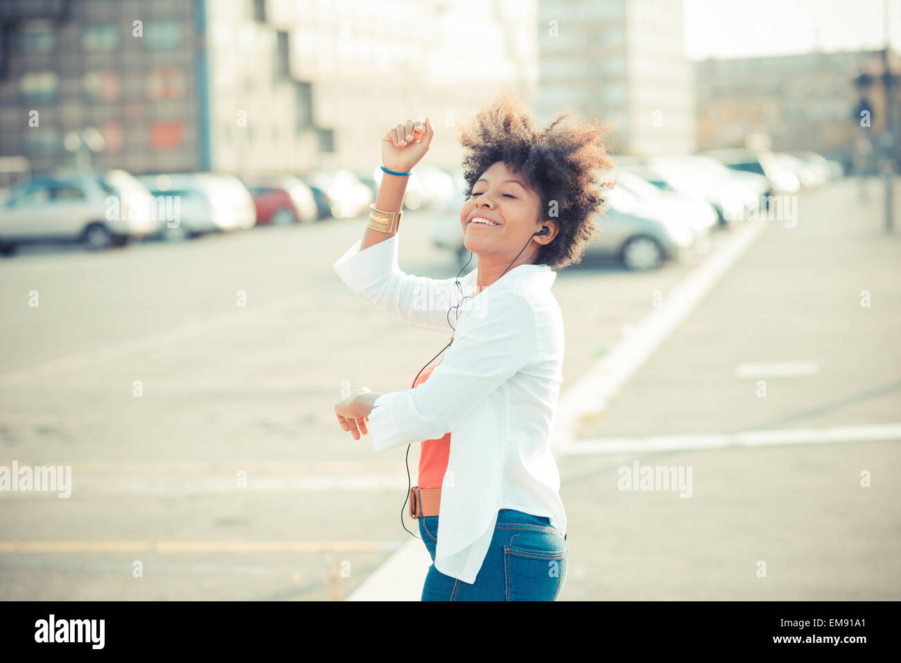 Junge Frau tanzen zur Musik über Kopfhörer in Stadt Stockfoto