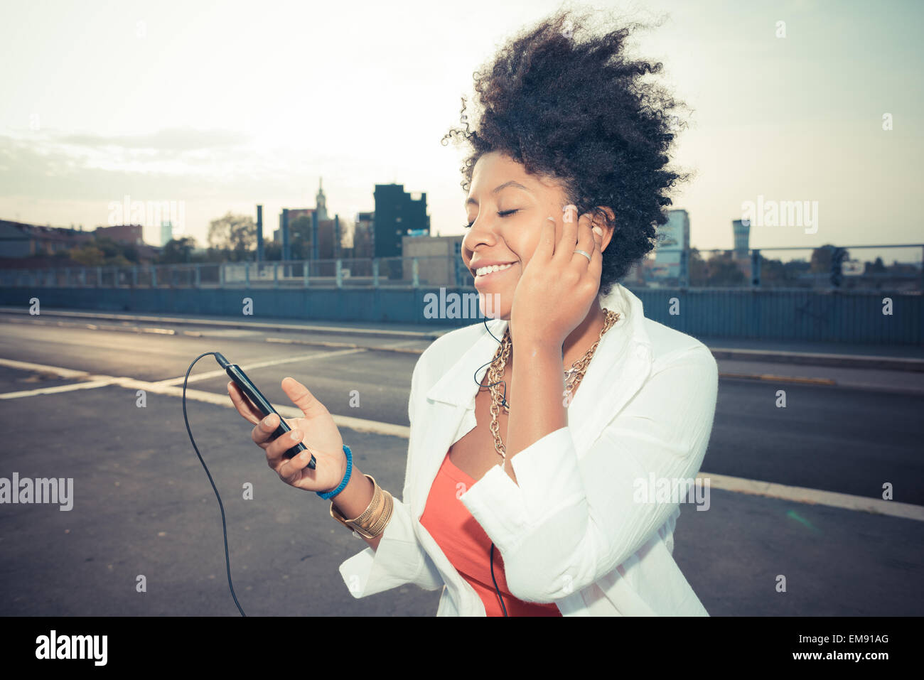 Junge Frau Smartphone Musikhören auf Parkplatz auf dem Dach Stockfoto