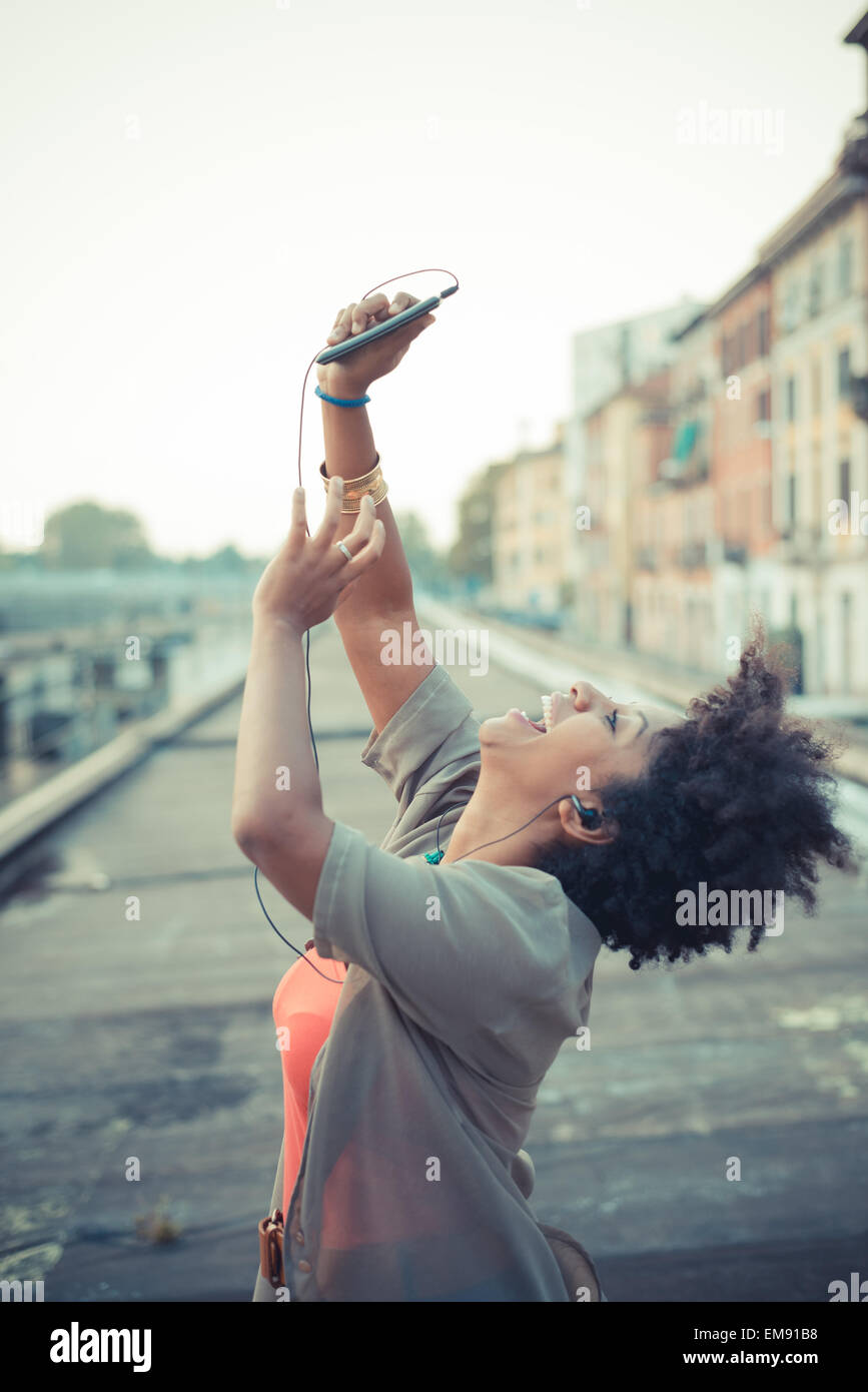 Junge Frau hält Smartphone im Industriegebiet der Stadt Stockfoto